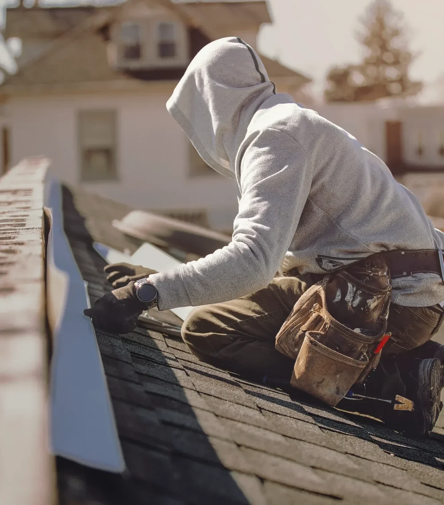 Roofer inspecting shingles and gutters on a residential roof
